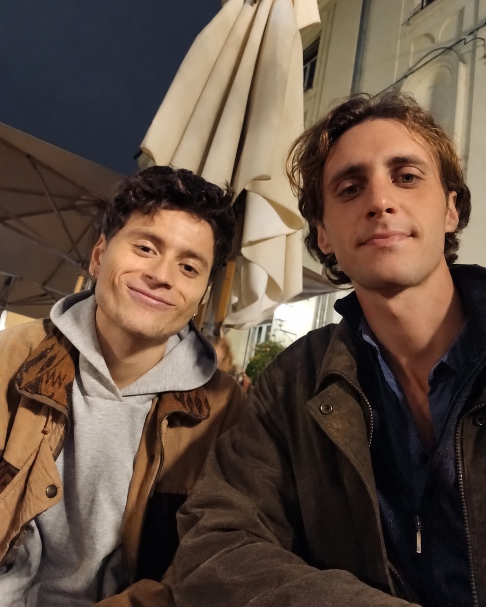 Marc y Javi sonriendo en una terraza de noche