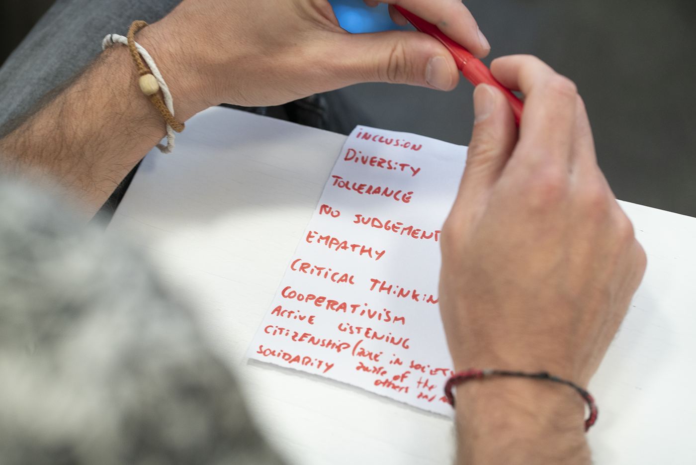 Hoja con valores escritos a mano: inclusión, empatía, pensamiento crítico